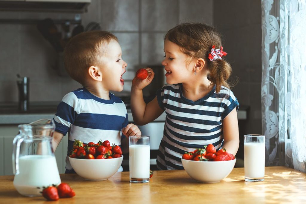 two kids snacking 